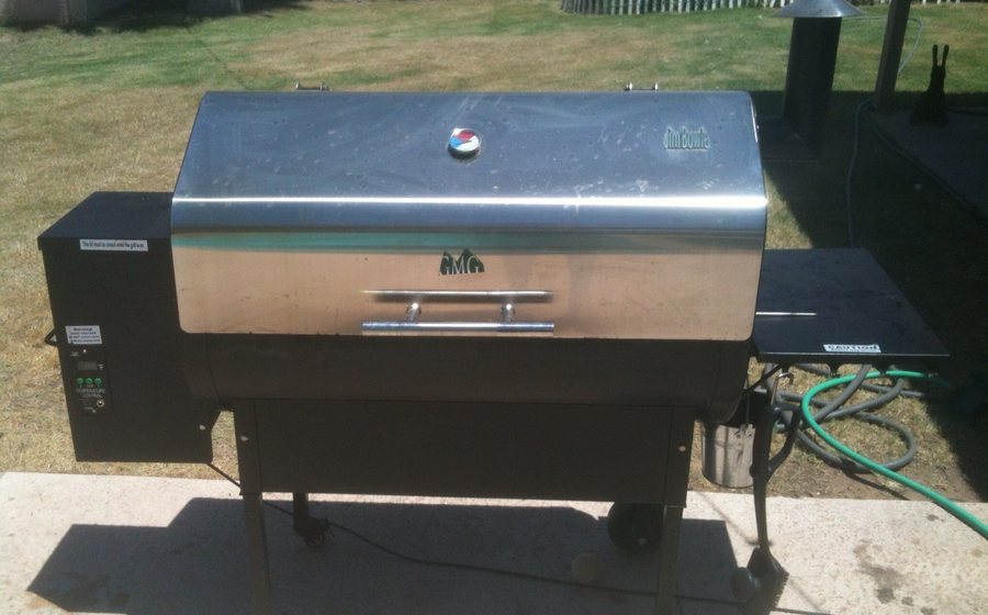Stainless wood-pellet smoker grill set up in a backyard